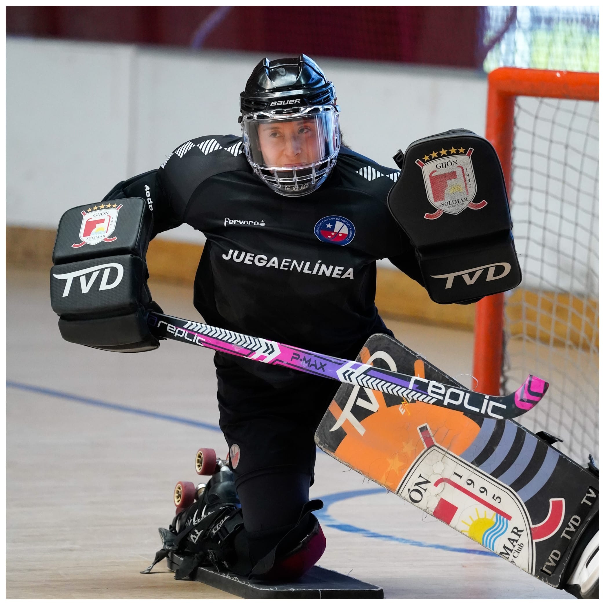 Arquero de hockey patín con equipo completo, arrodillado en el arco