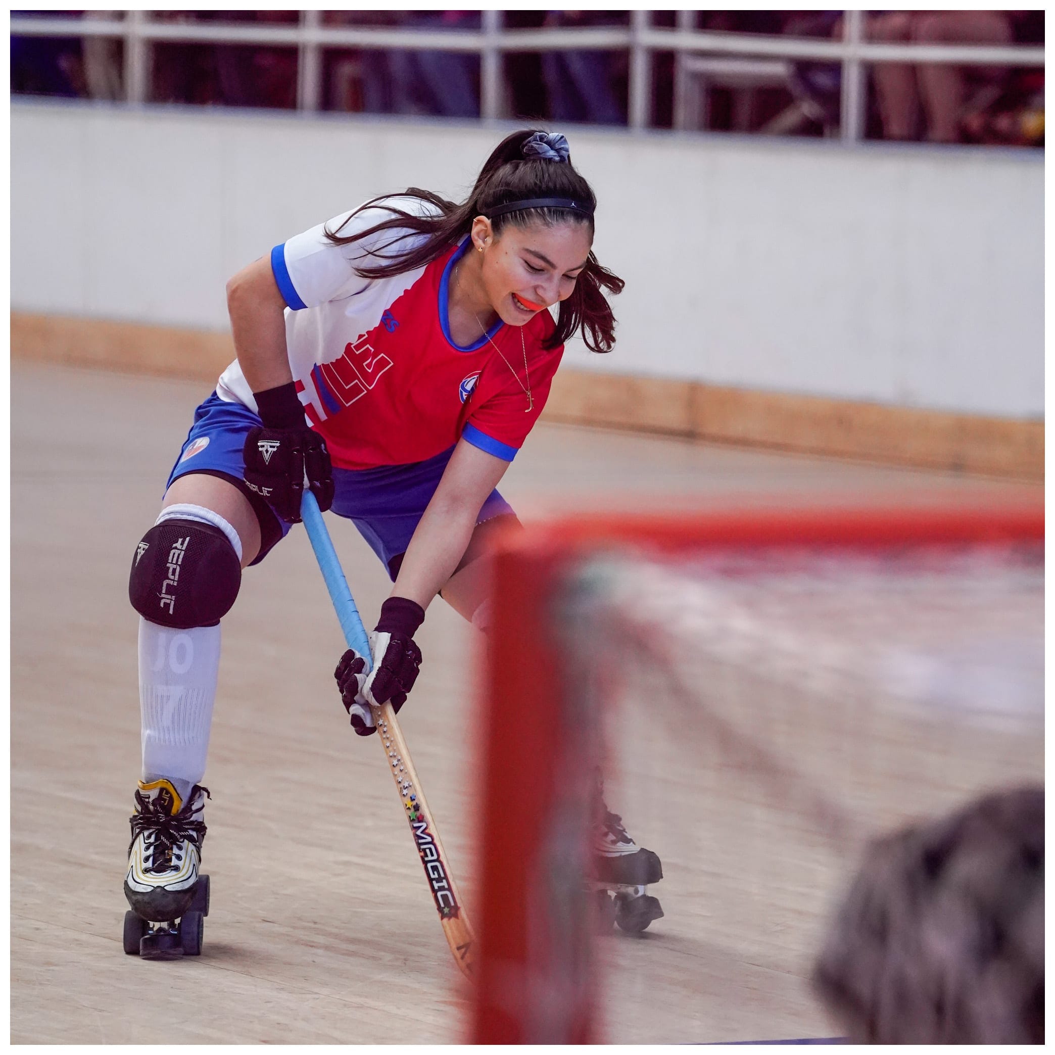 Jugadora de hockey patín llevando la bocha frente al arco