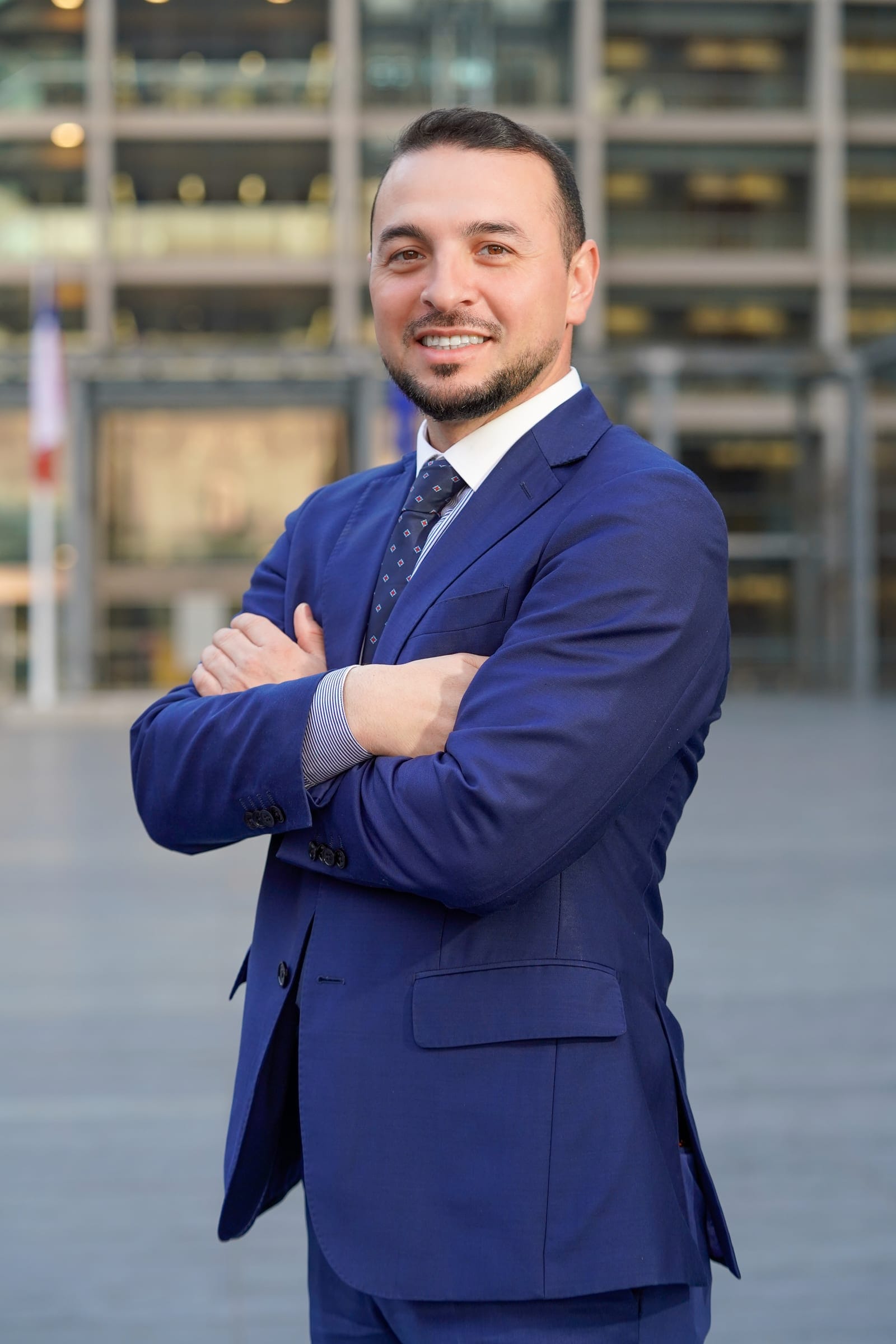 Retrato profesional de un hombre de traje azul con los brazos cruzados